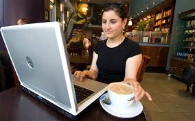Photo: Woman works on computer at cafe